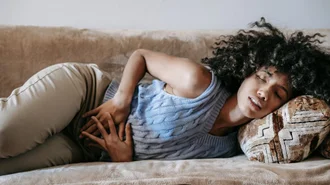 woman laying on the couch with the stomach ache