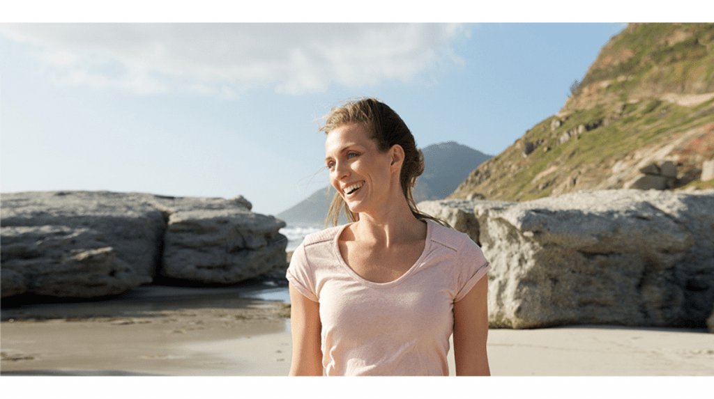 Woman standing on a rocky beach on a sunny day