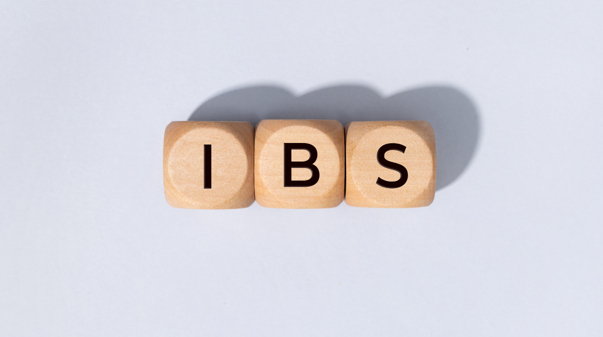 Wooden letter blocks spelling IBS on a light grey background